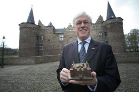Burgemeester Jacobs met het nieuwe relatiegeschenk van Helmond Promotions: een replica van het Kasteel. Foto Ton van de Meulenhof